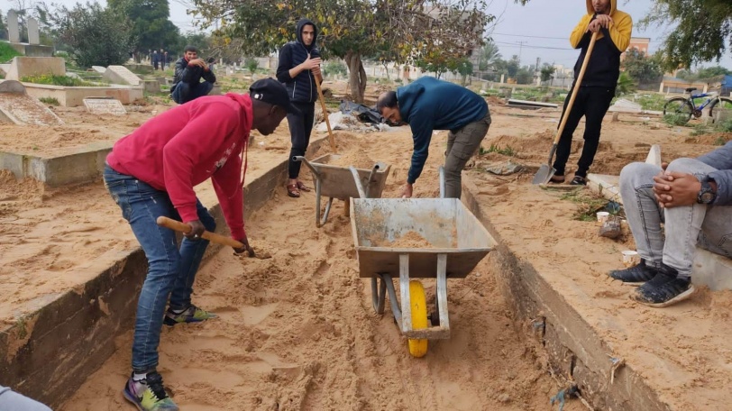 متطوعون يشاركون في تنظيف ما خلفته الآثار الناجمة عن فتح عبارات مياه الأمطار على مقبرة المصدر