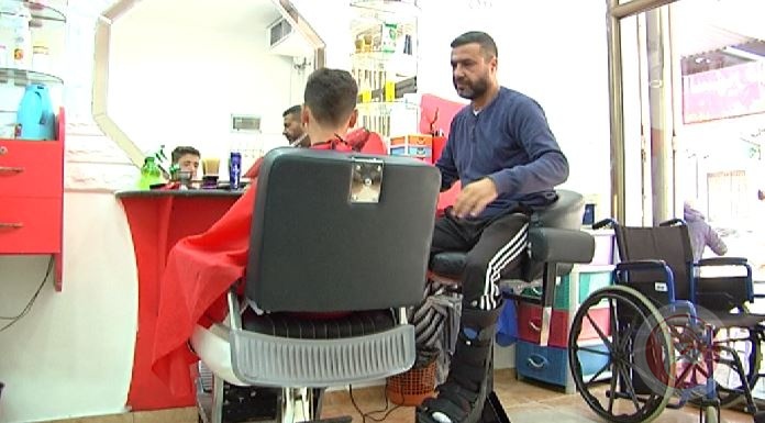 "حلّاق" على كرسي متحرك بغزة
