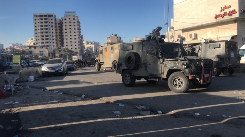 The occupation arrests two young men from Qalandiya camp and destroys vehicles