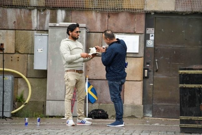 موميكا مع مهاجر عراقي آخر يحرقان نسخة من القرآن قرب برلمان السويد