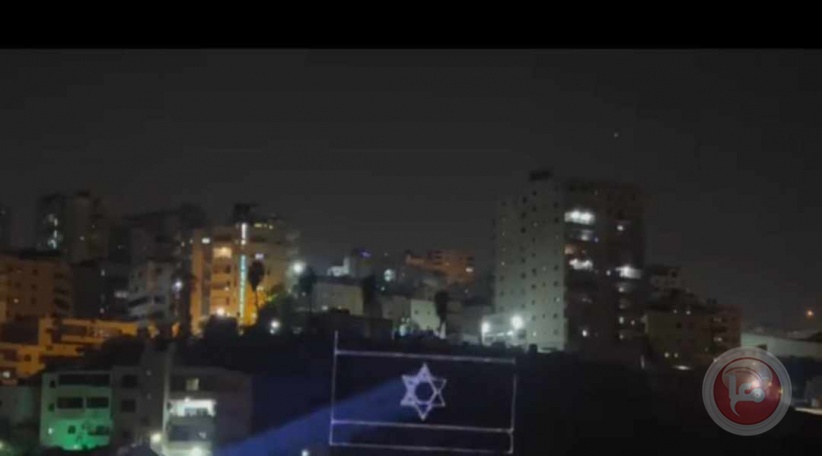 Shuafat Camp - Settlers illuminate the “Israeli flag and the people of Israel are alive”  towards the houses