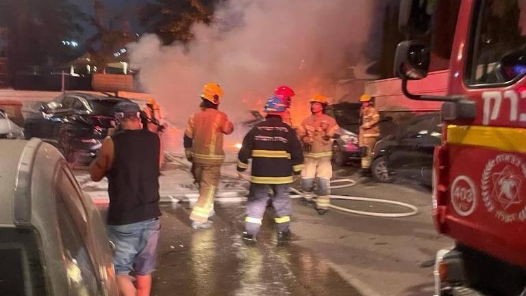 Fire crews try to put out a fire that broke out in a parking lot in Kiryat Ono