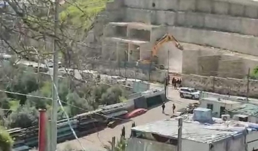 Occupation bulldozers demolish walls in the town of Silwan