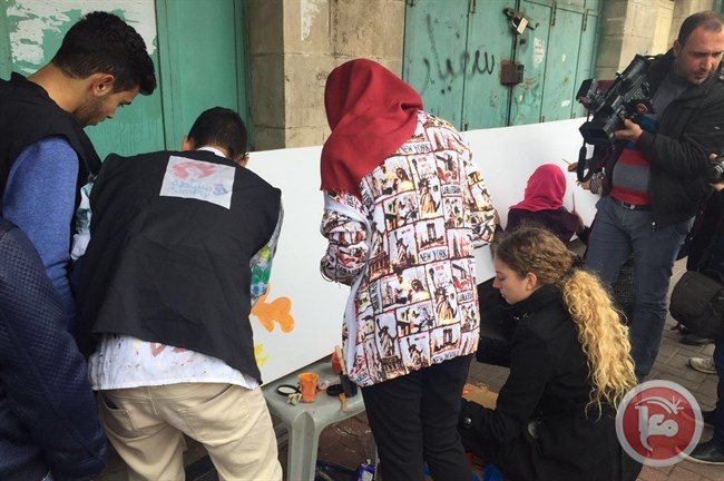 فنانون يواجهون الاحتلال بجداريات امام حاجز بالخليل
