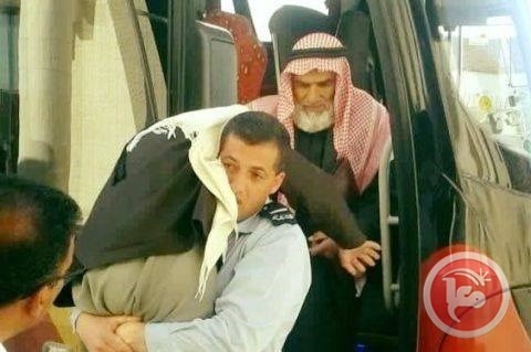 شرطي يحمل مسنا على كتفه على معبر الكرامة