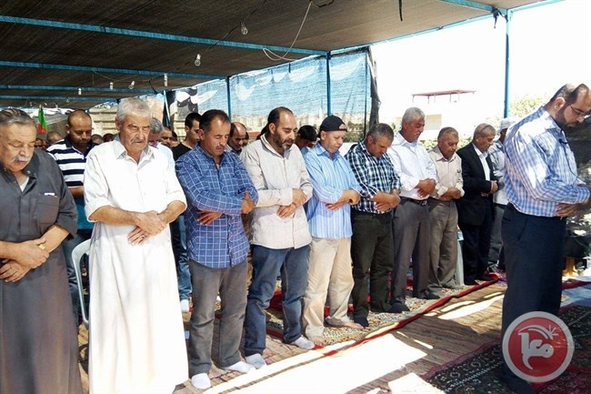 أهالي قلنديا يؤدون الصلاة بجانب أنقاض منازلهم