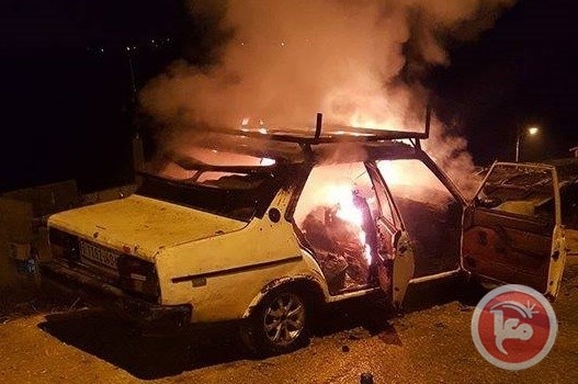 مستوطنون يحرقون مركبتين ويخطون شعارات عنصرية