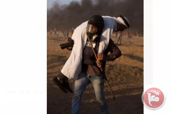صورة - الصحفي حاتم عمر يسعف مسنا على الحدود