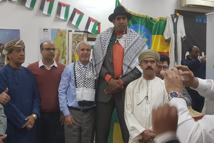 الكوفية على أكتاف المرشح للقب أطول رجل في العالم